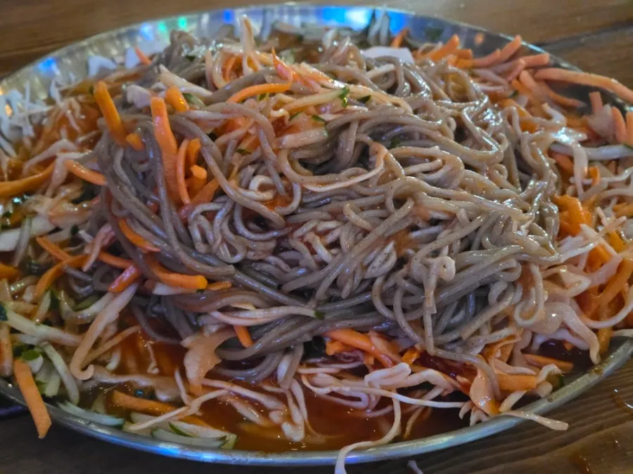 Slushy-ice makguksu mixed with gloves on