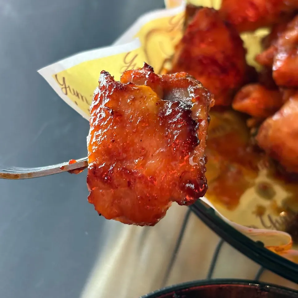 Rice cake and chicken picked up together in one bite