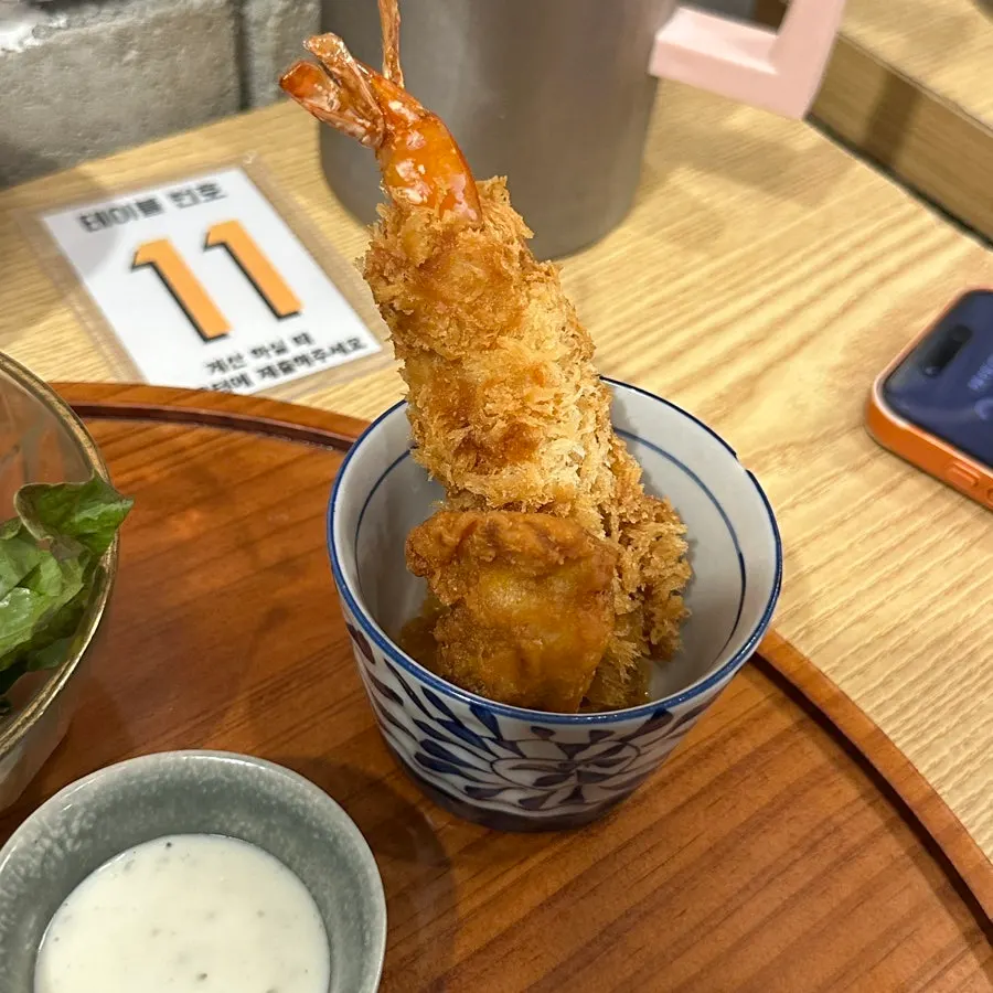 Salad, inari sushi, and shrimp tempura side dishes