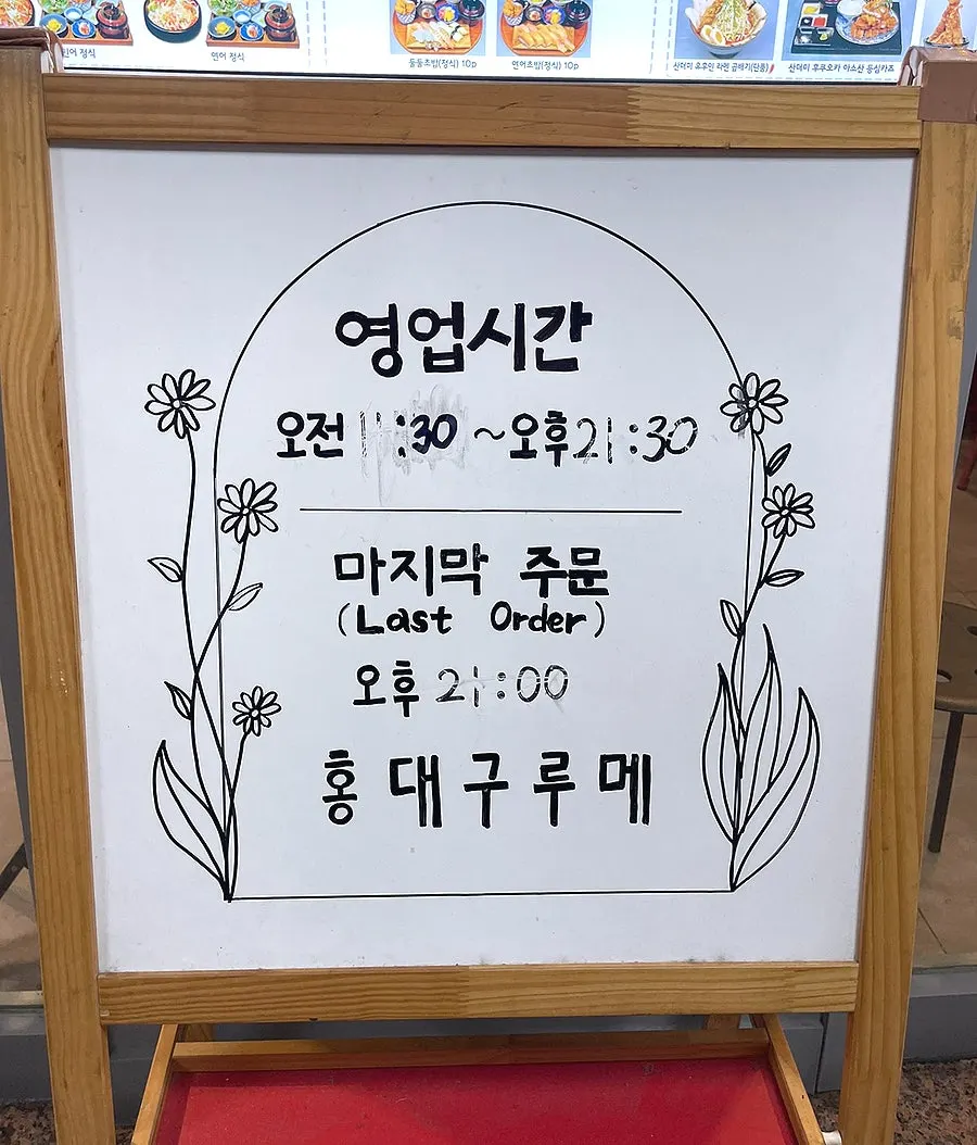 Standing sign in front of the restaurant showing business hours