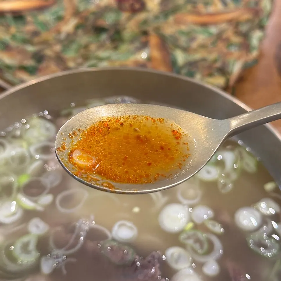 Spicy hanwoo yangtang with minced garlic and chili stirred in