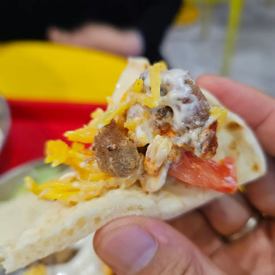 Meat and vegetables piled on top of the flatbread