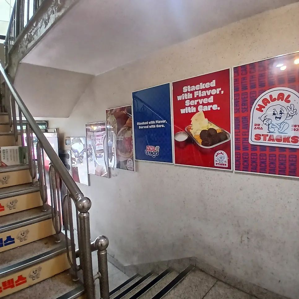 Menu signage on the stairwell wall at Halal Steaks