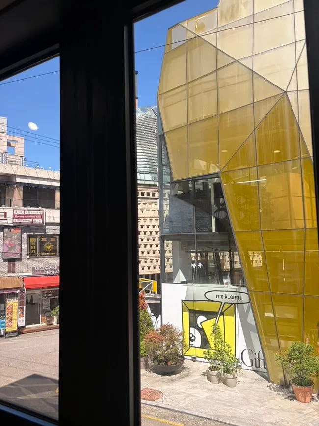 View of the A-Land building across the street from the window seat at Halal Steaks