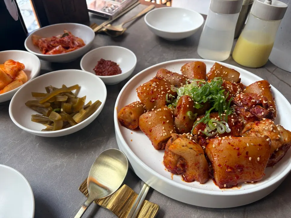 Red pork tail jjim topped with scallions and sesame seeds