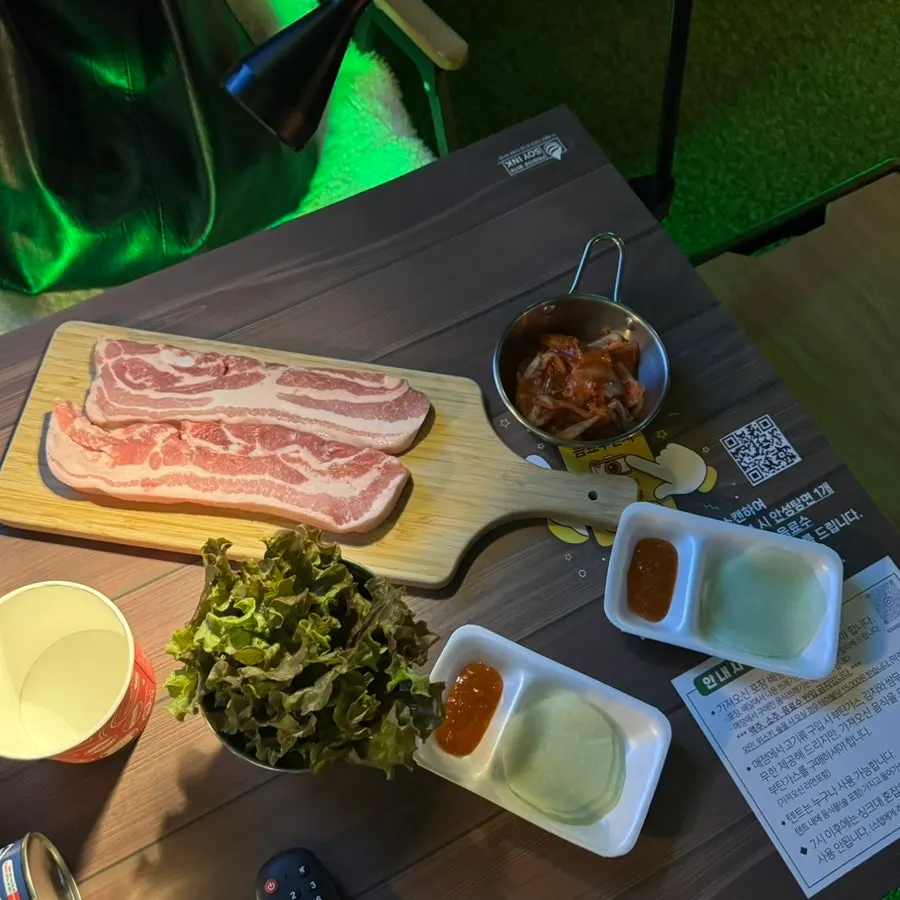 불판에서 익어가는 삼겹살과 구운 김치