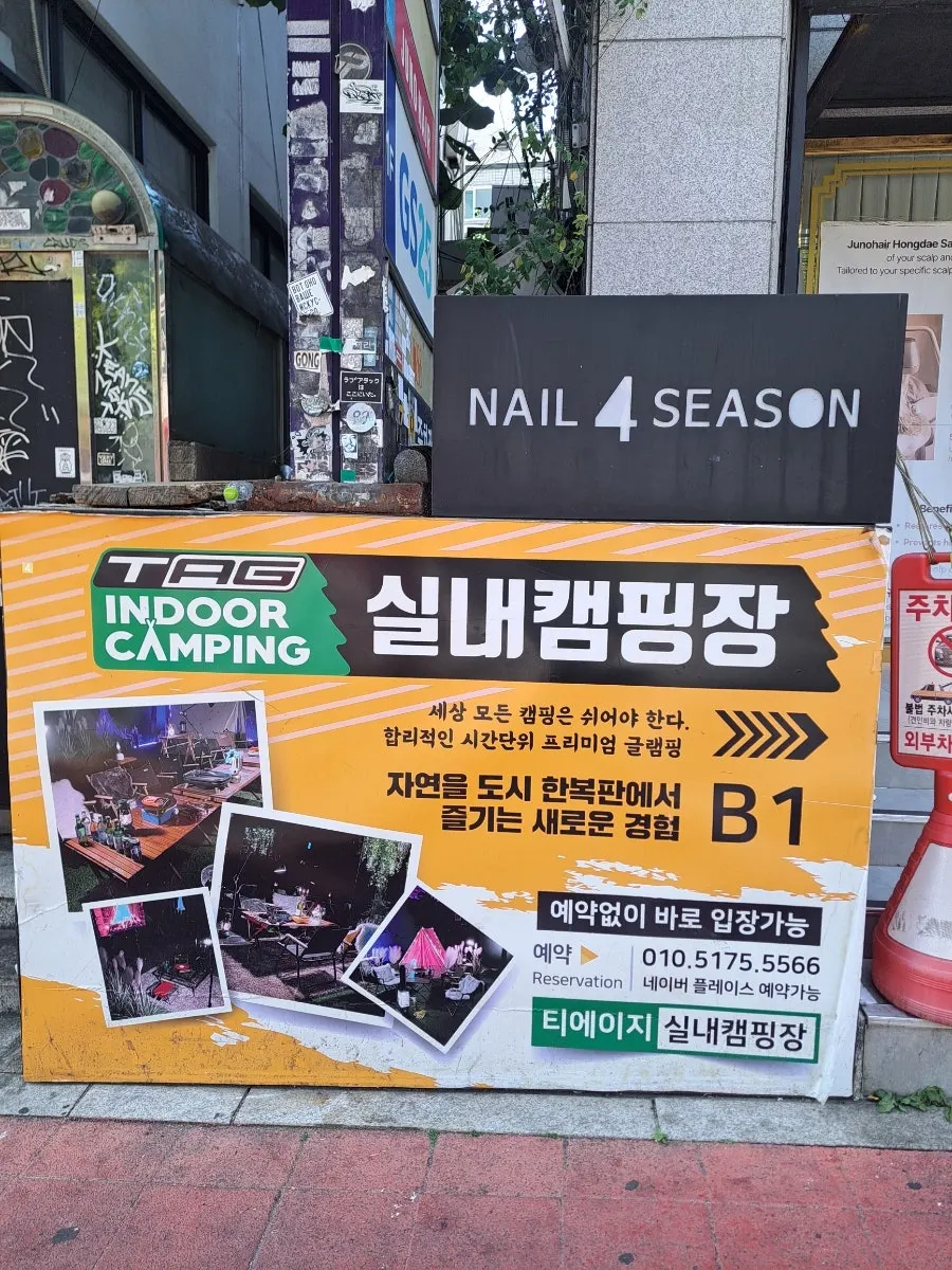 잔디 느낌 바닥재와 조명이 있는 실내 캠핑장
