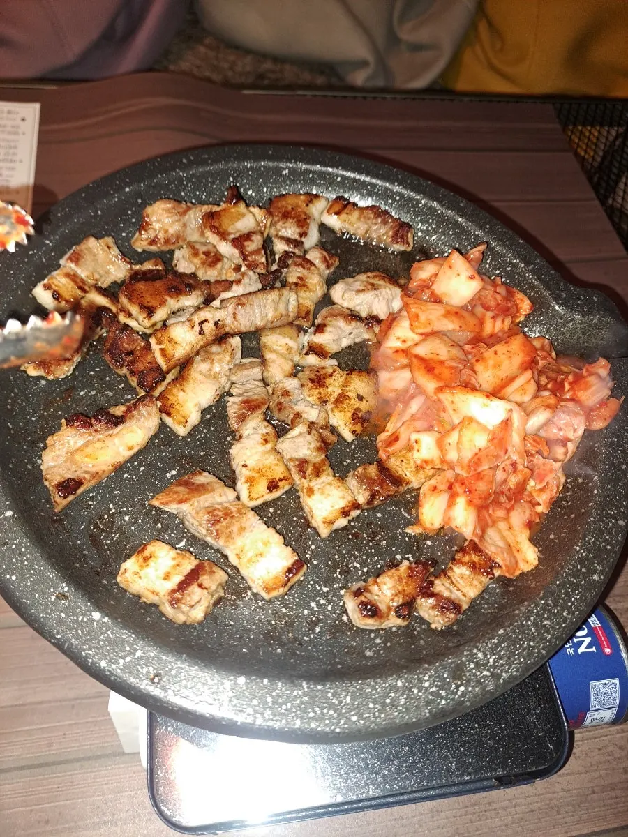 삼겹살을 구운 김치에 싸 먹는 모습
