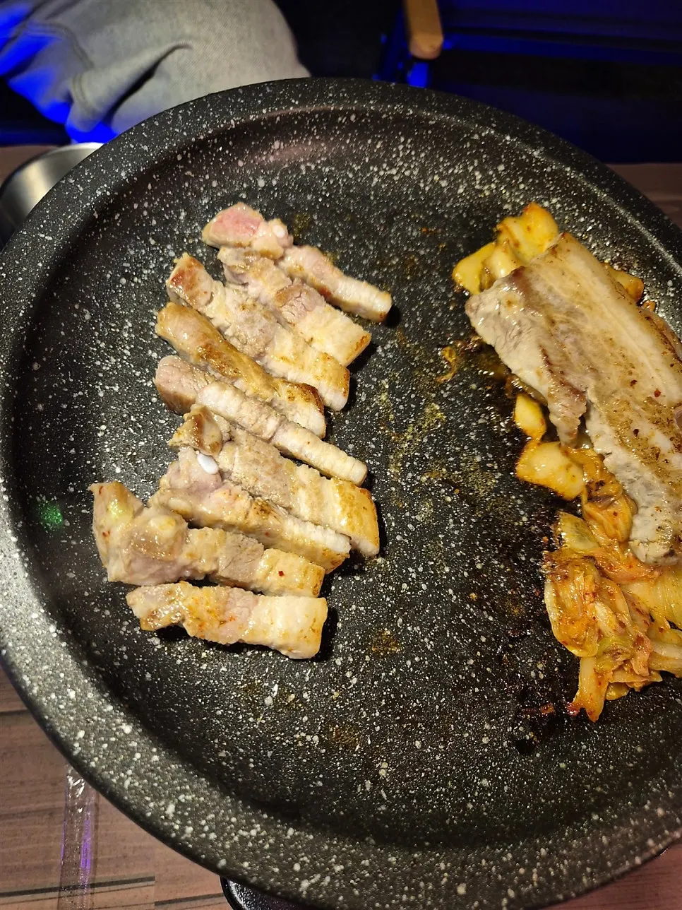 Pork belly grilling with kimchi on the burner