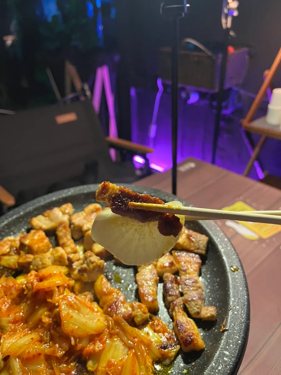 露營燈光下享用五花肉的用餐場景