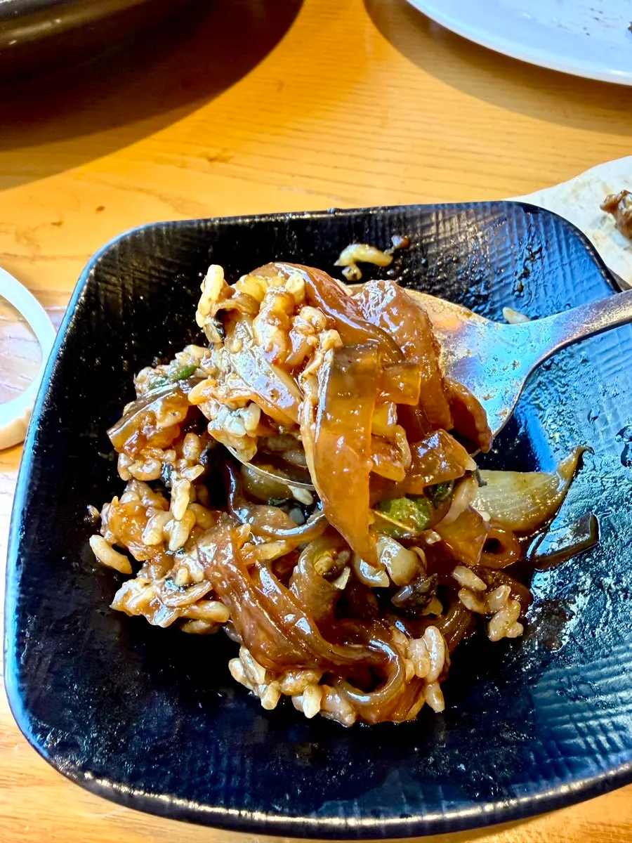 A bite of ongbap wrapped with perilla leaf and seaweed