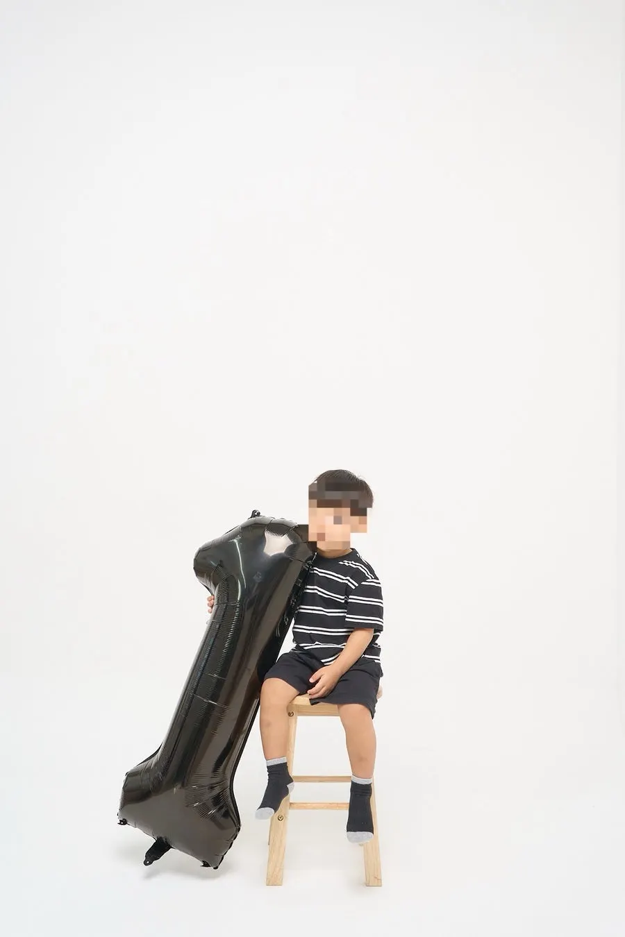 Sibling milestone photos using a large balloon