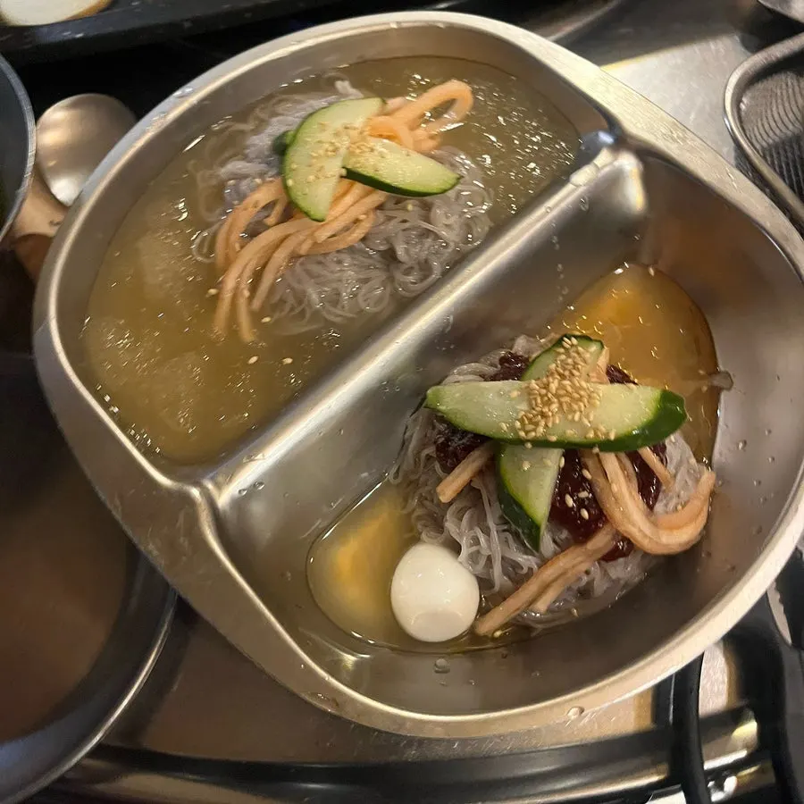 Half-and-half naengmyeon with water and spicy noodles side by side