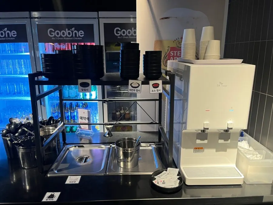 Self-serve bar with water, utensils, and pickled radish