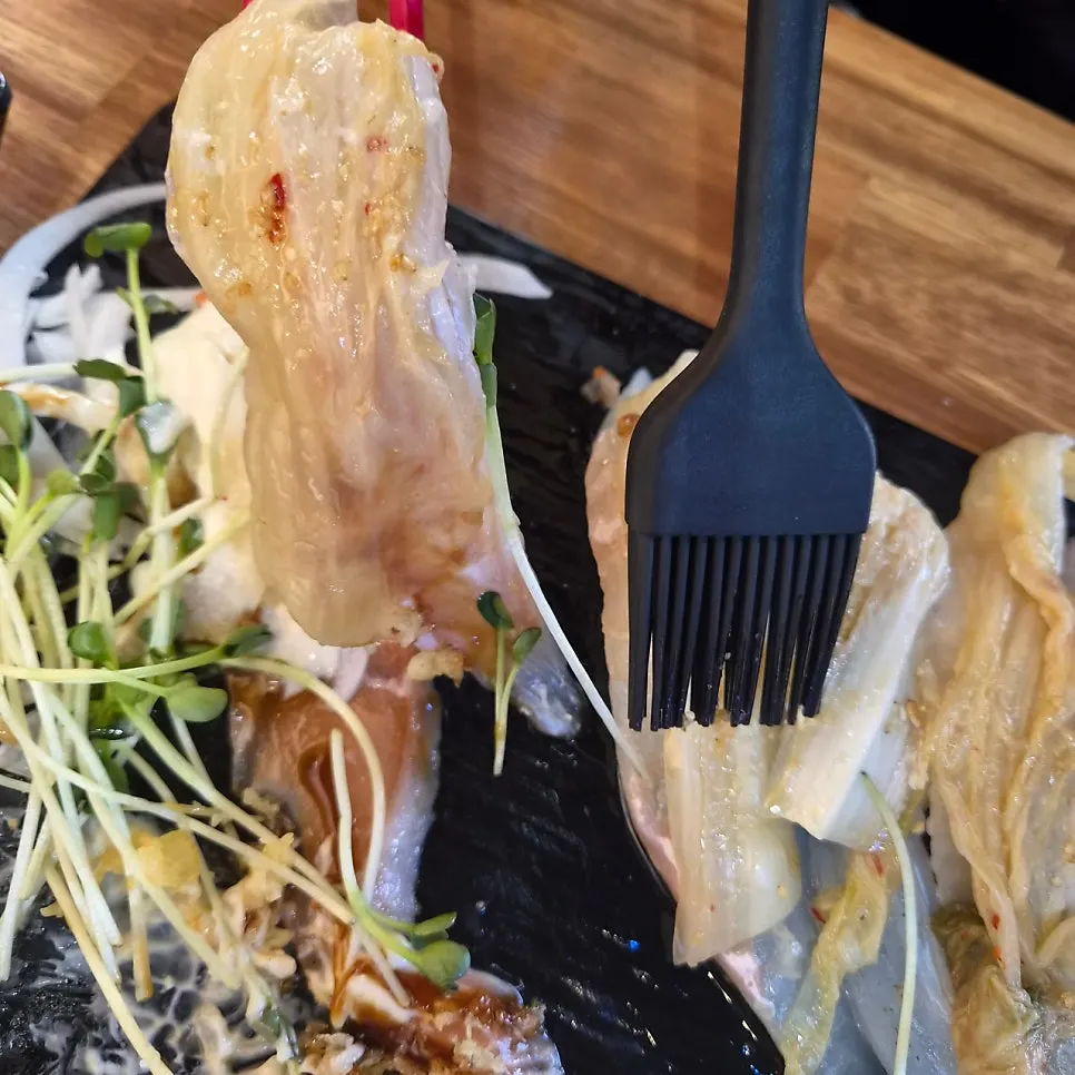 Extra-long sushi being brushed with soy sauce