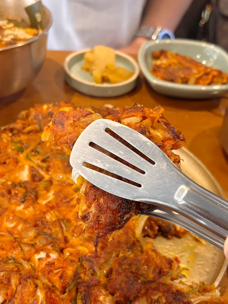 A crispy-edged piece of the meat kimchi pancake