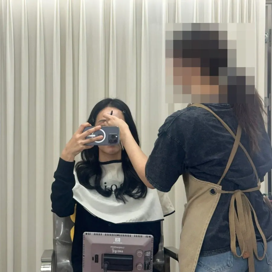 웨이브를 말고 베이스 메이크업을 받는 모습