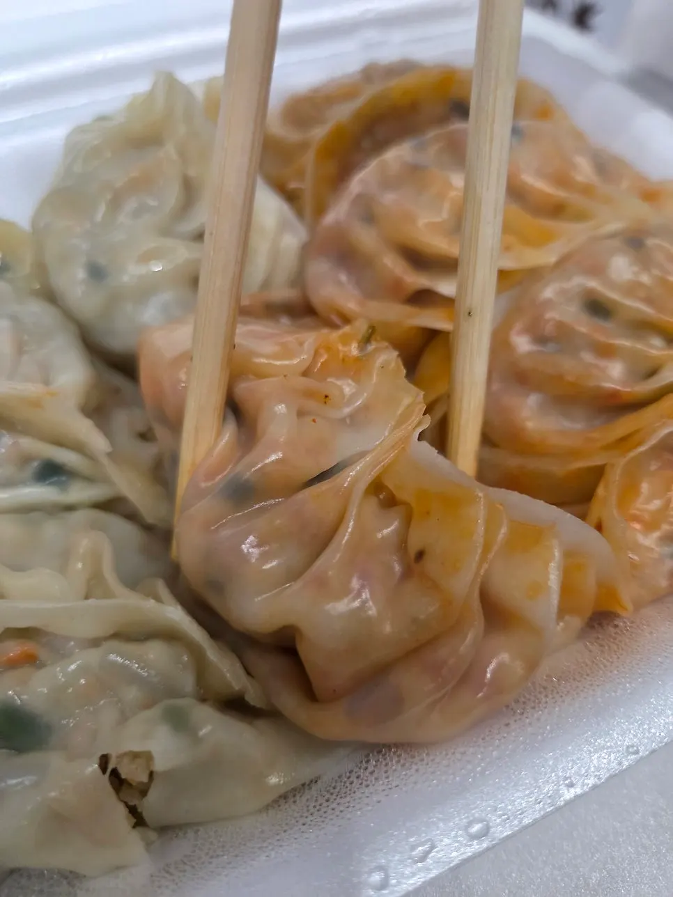 Close-up of okonomi gyoza covered in sauce and bonito flakes