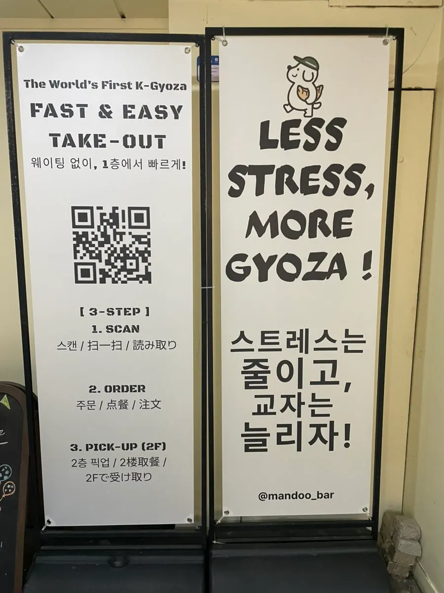 QR takeout ordering sign in front of MANDOO BAR's entrance
