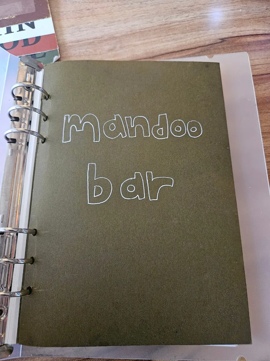Sign featuring MANDOO BAR's mascot character Mangdu-ung