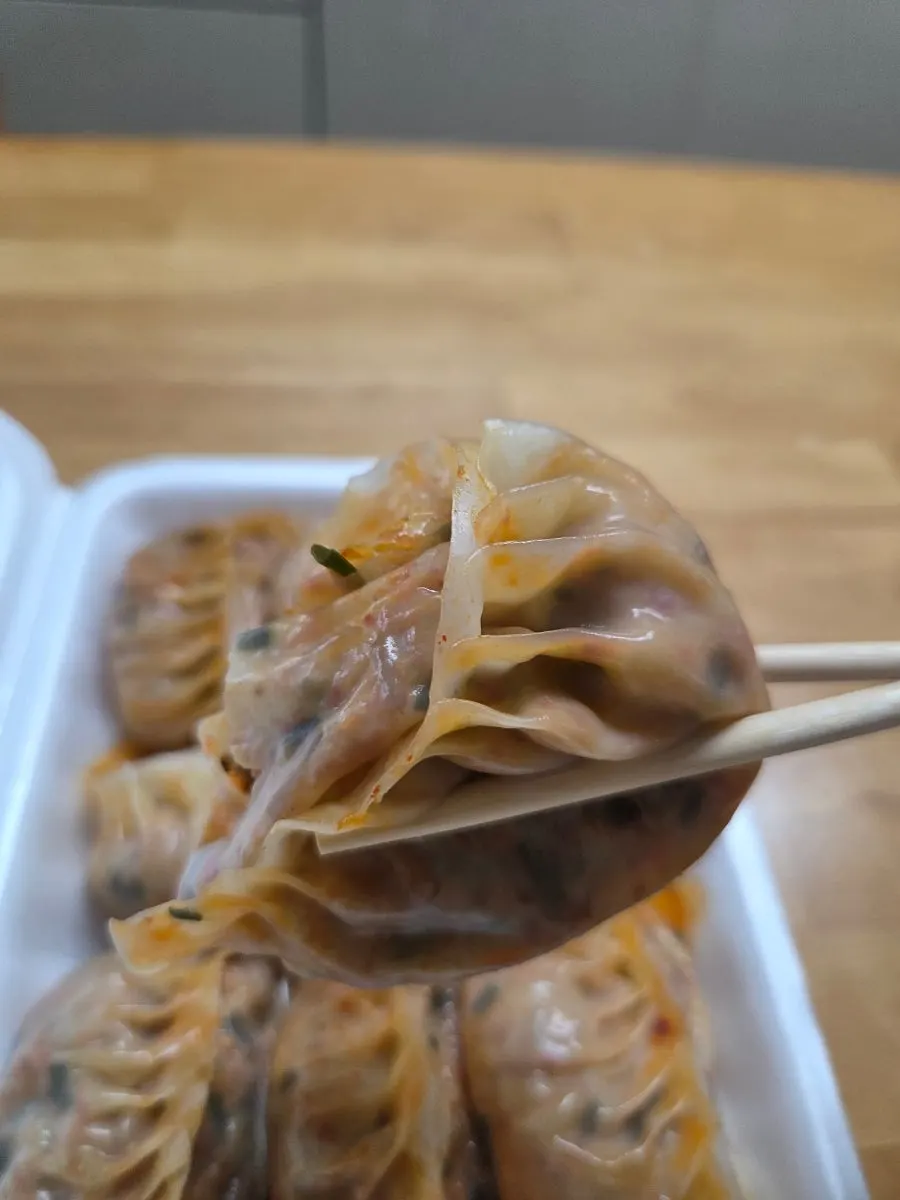 A bite of steamed dumpling topped with seasoned pickled radish