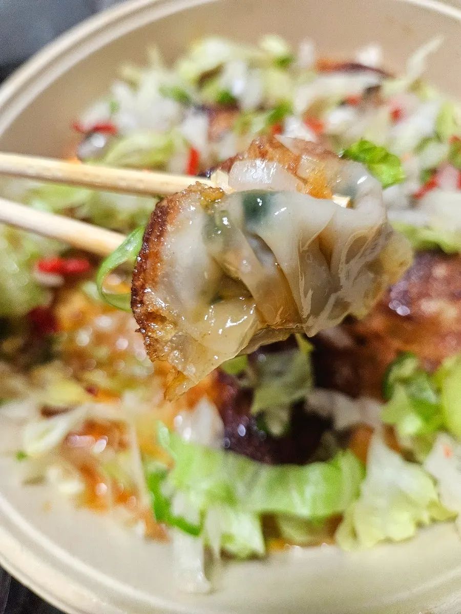 Picking up a piece of yurinki gyoza with vegetables