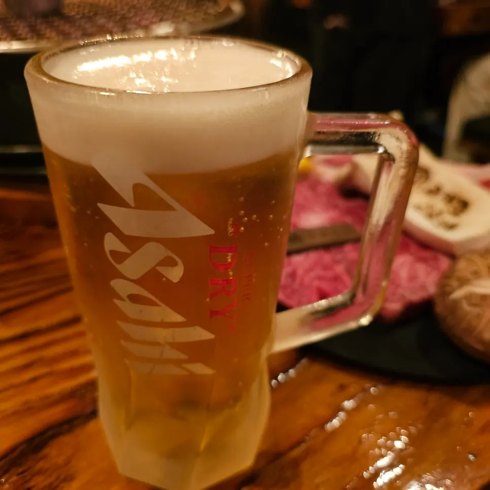 A glass of Asahi draft beer with a head of foam