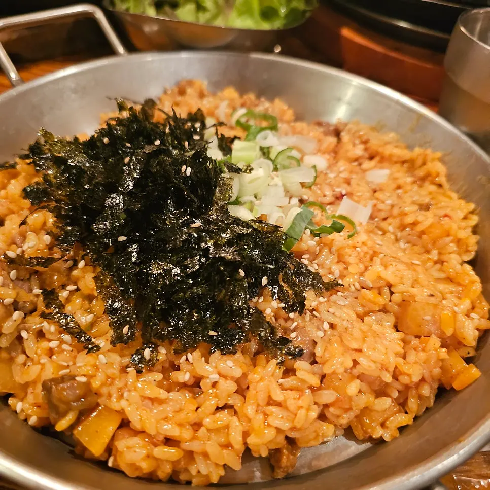 Kkakdugi-bap fried rice topped with seaweed flakes and green onion