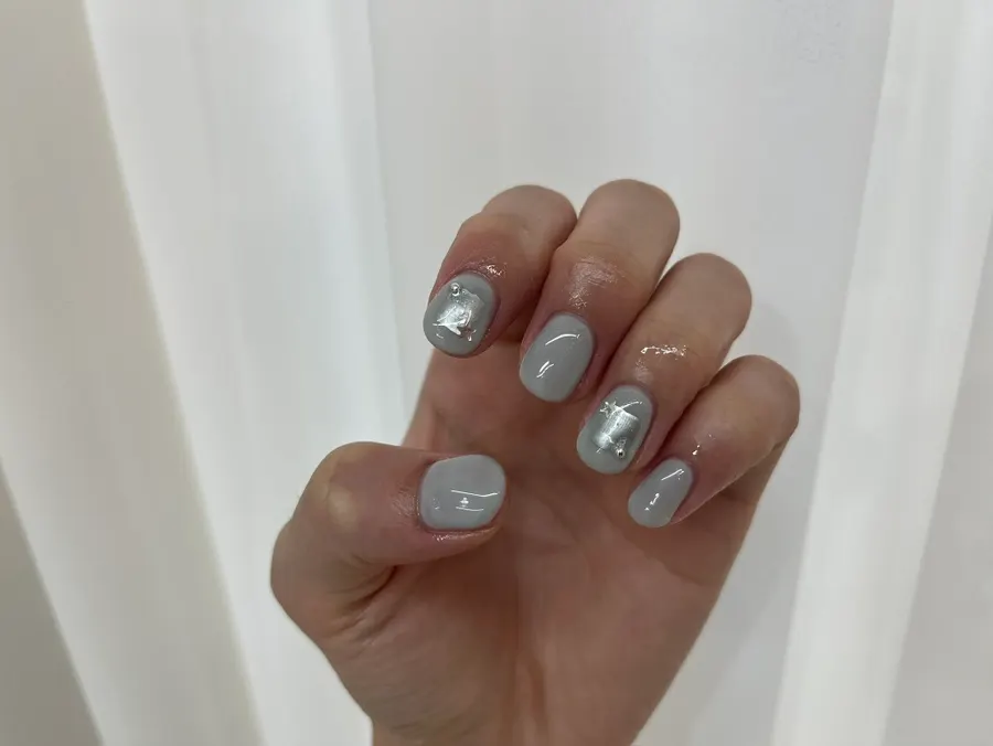 A hand mid-way through gel nail application