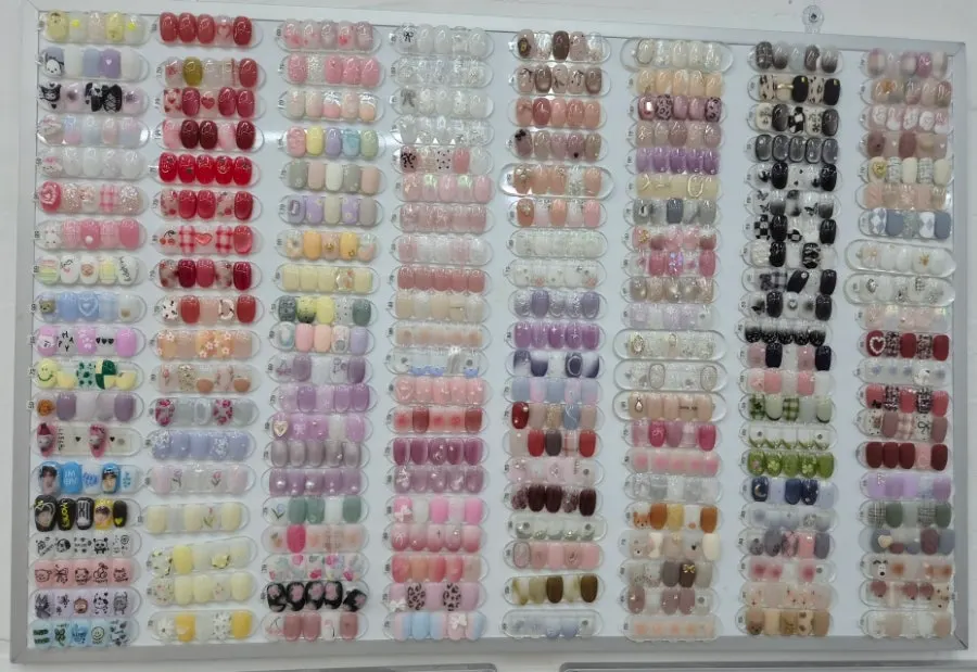 A variety of nail design samples displayed on the wall