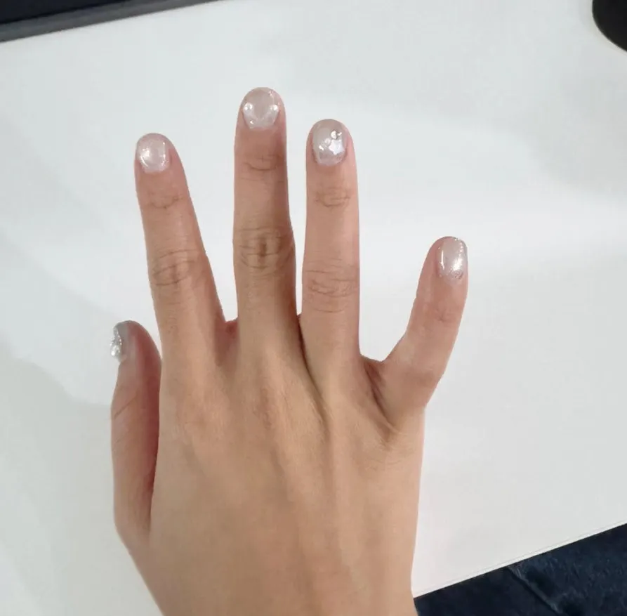 Hand with silver gel nails ready for a dress fitting