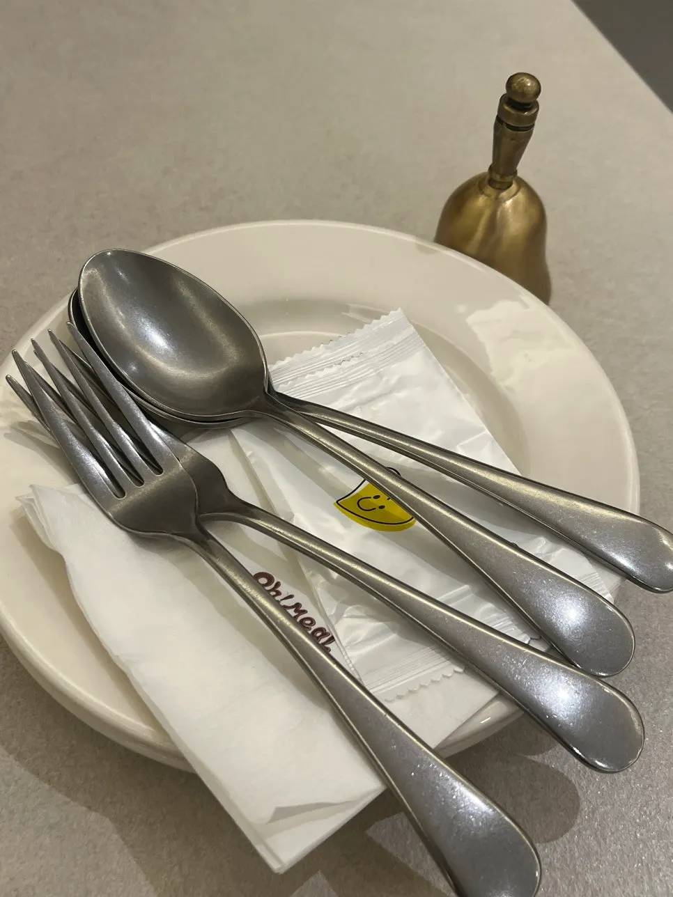 Basic table setting with side plate, utensils, and order bell