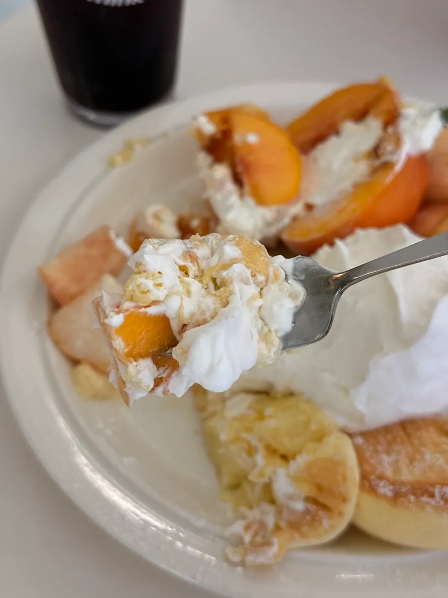 Spoonful combining Greek yogurt and peach