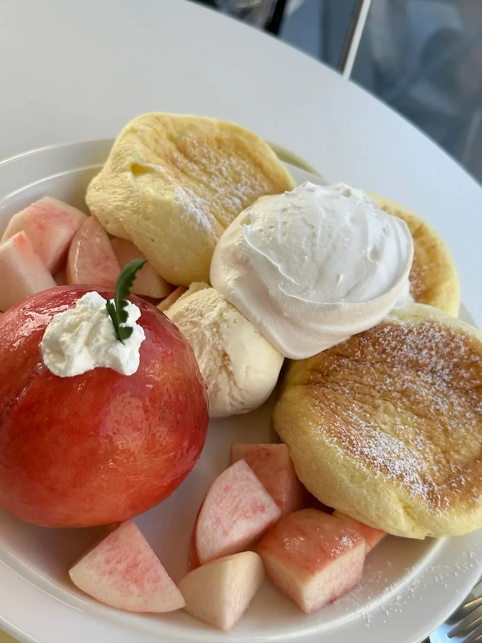Three soufflé pancake pieces with peach toppings