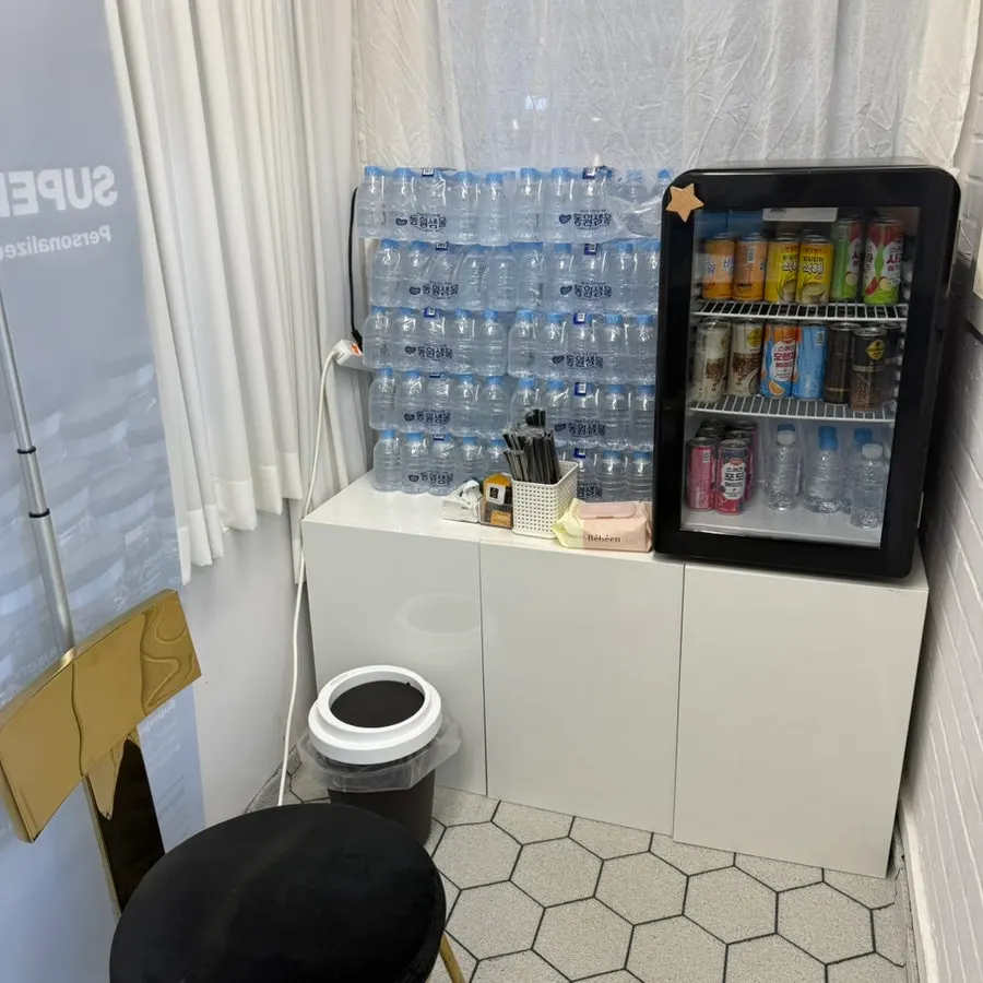 Area near the fridge stocked with water and drinks