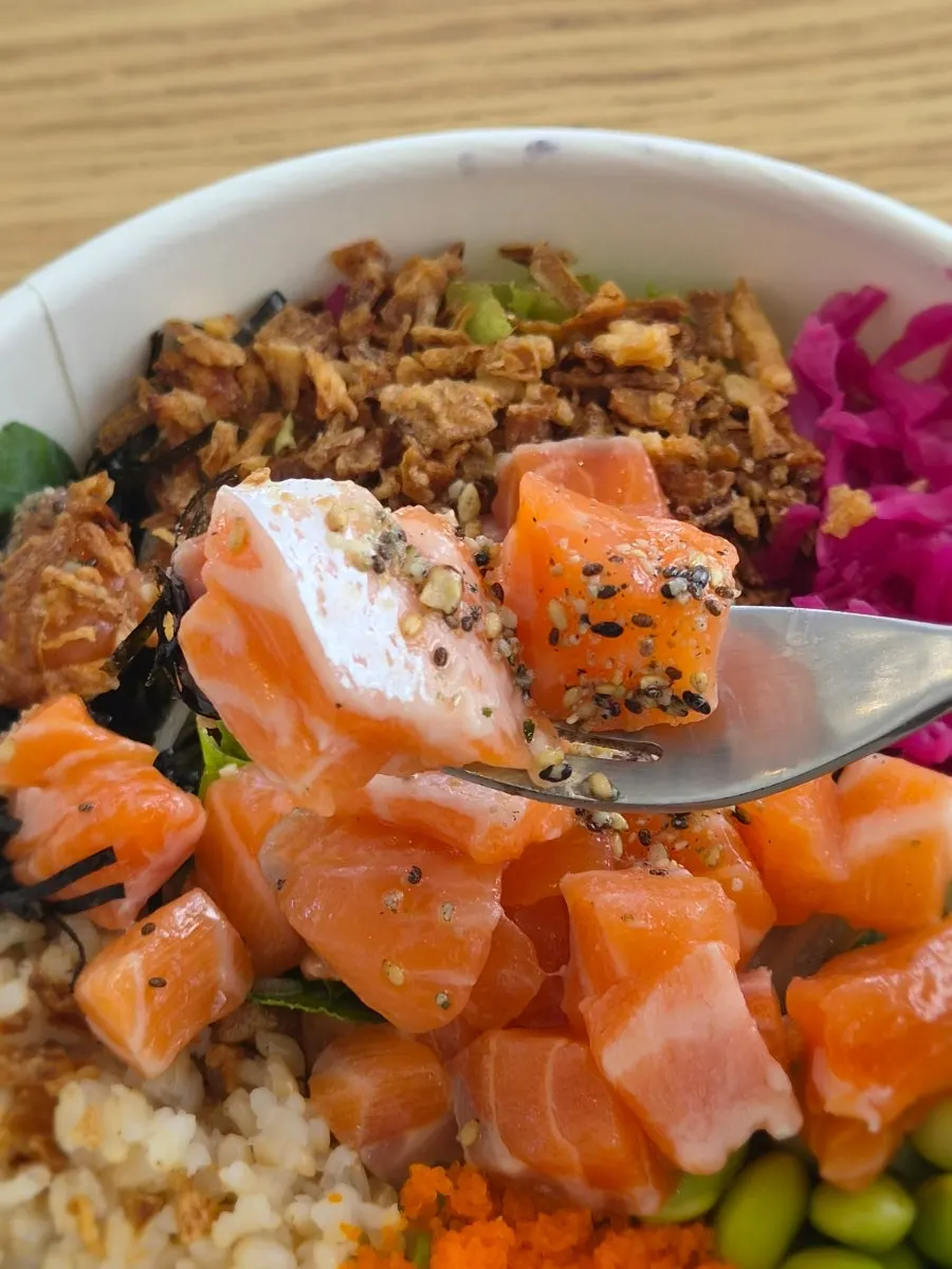A bite taken from the salmon poke bowl