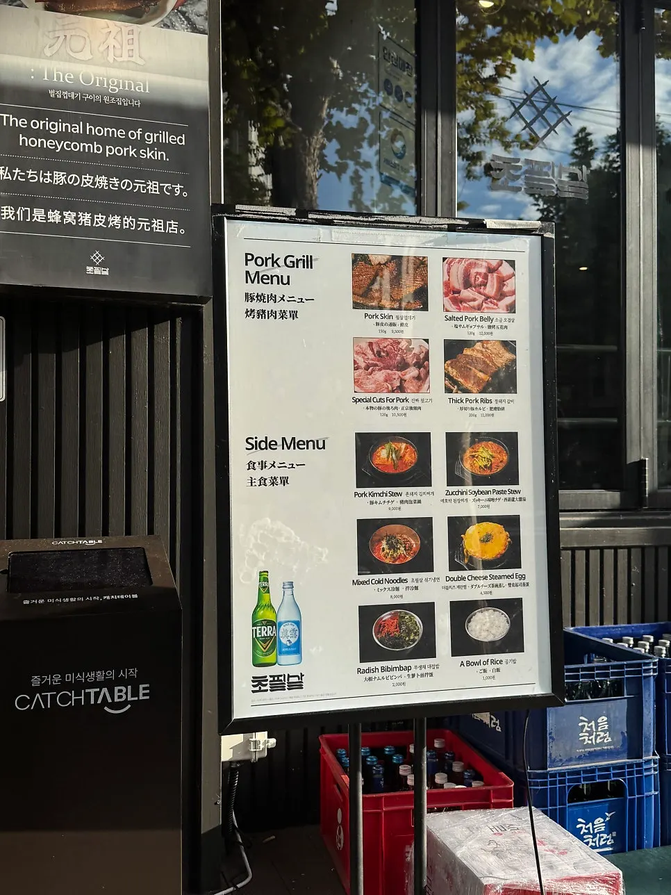 Menu board in four languages set up outside the entrance