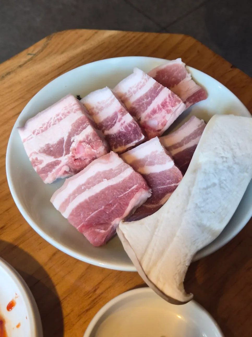 Thick salted ogyeopsal served with a whole king oyster mushroom