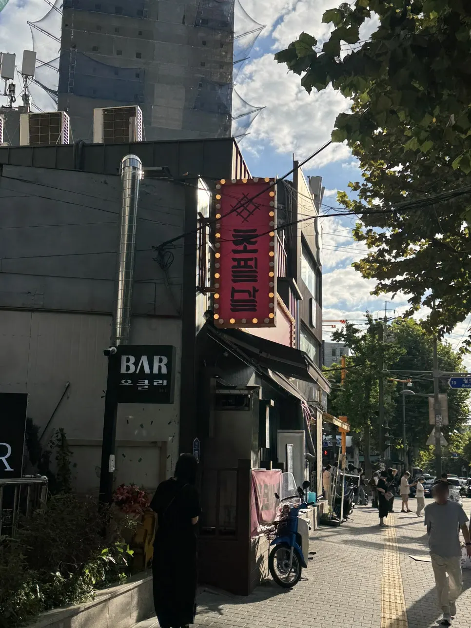 Red projecting sign visible from the alley