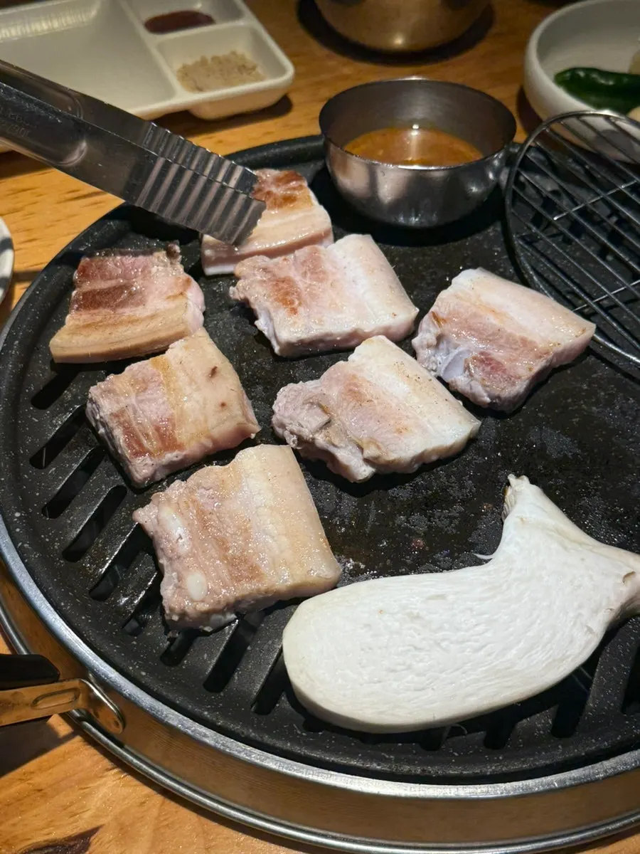 Close-up of ogyeopsal cooking on the grill