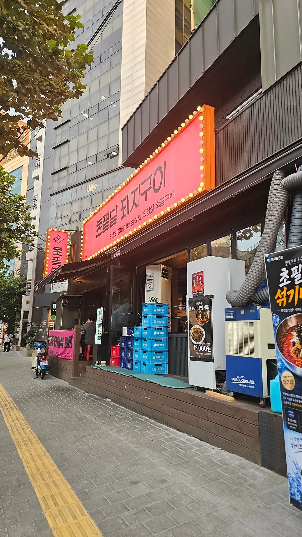 Exterior of Chopilsal Pork Grill Hongdae Branch with red signage and lighting