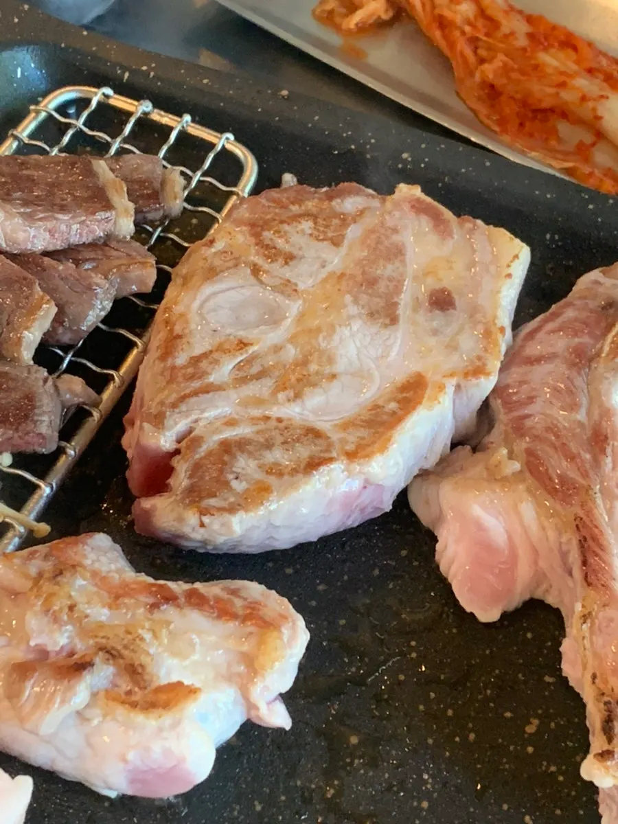 Grill beginning to cook Korean pork