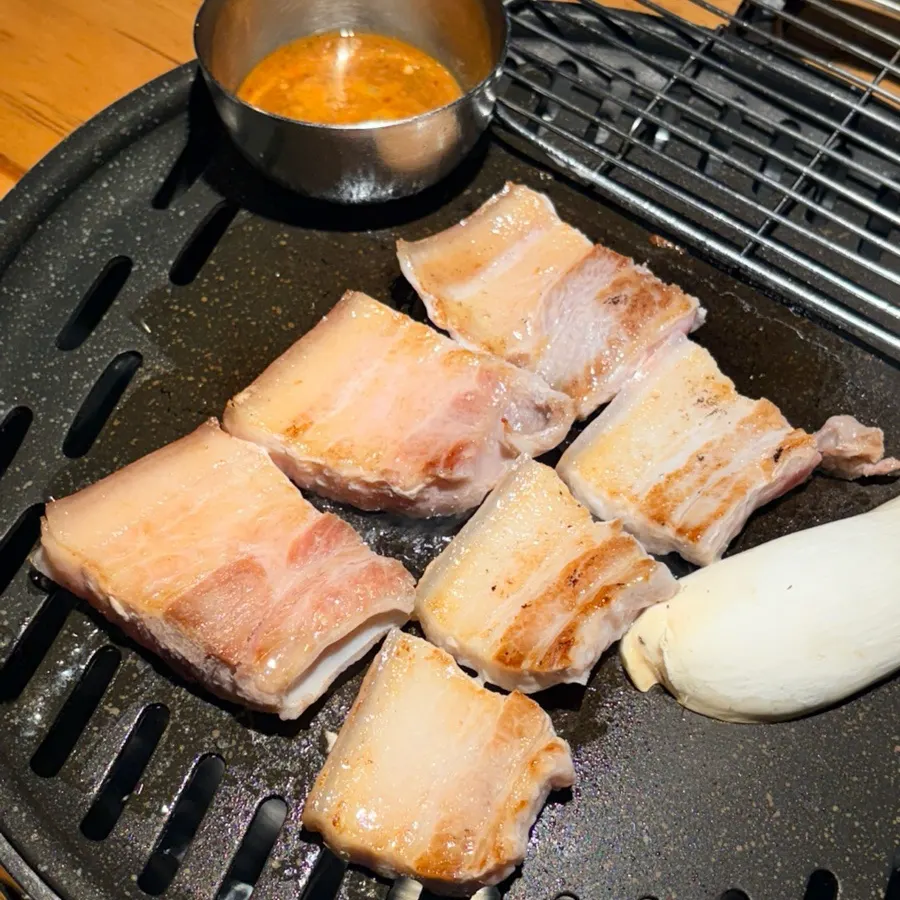 Salted ogyeopsal placed on the grill with mushrooms