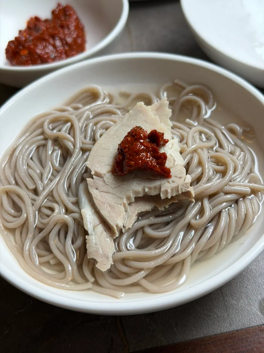 A bowl of Pyongyang naengmyeon with mild broth