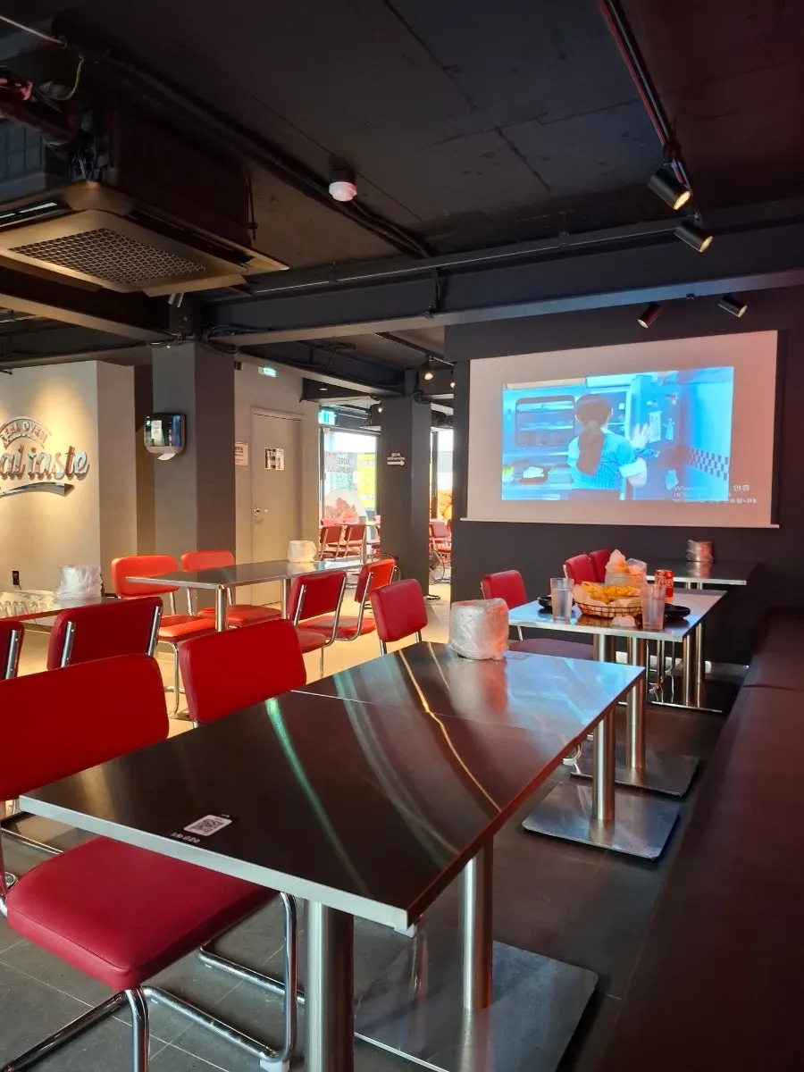 Store interior with silver tables and red chairs
