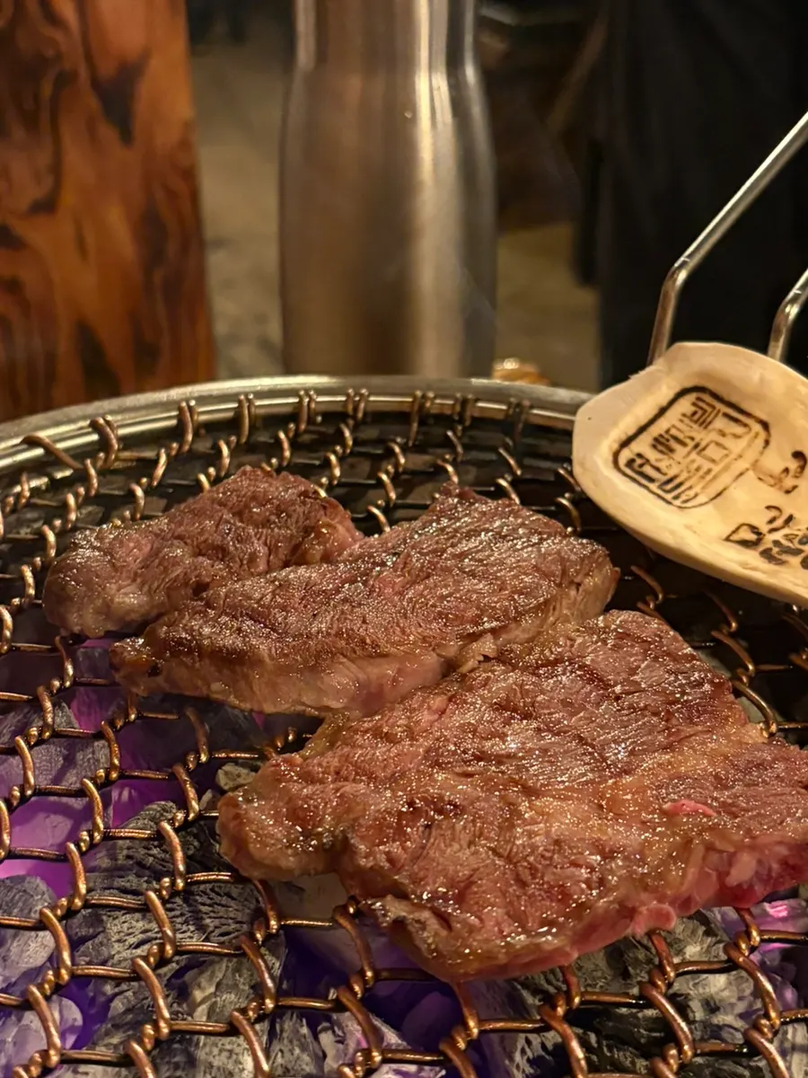 A staff member grilling meat on the wire grill