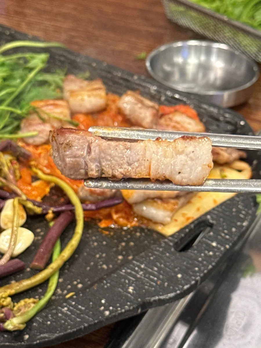 Thick-cut pork belly, pre-seared over charcoal, cooking on the stone grill plate