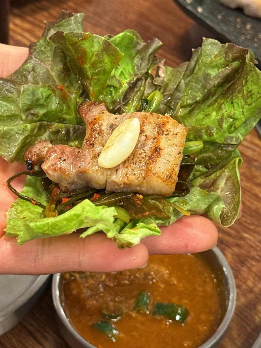 A piece of pork belly dipped in the house-made ssamjang