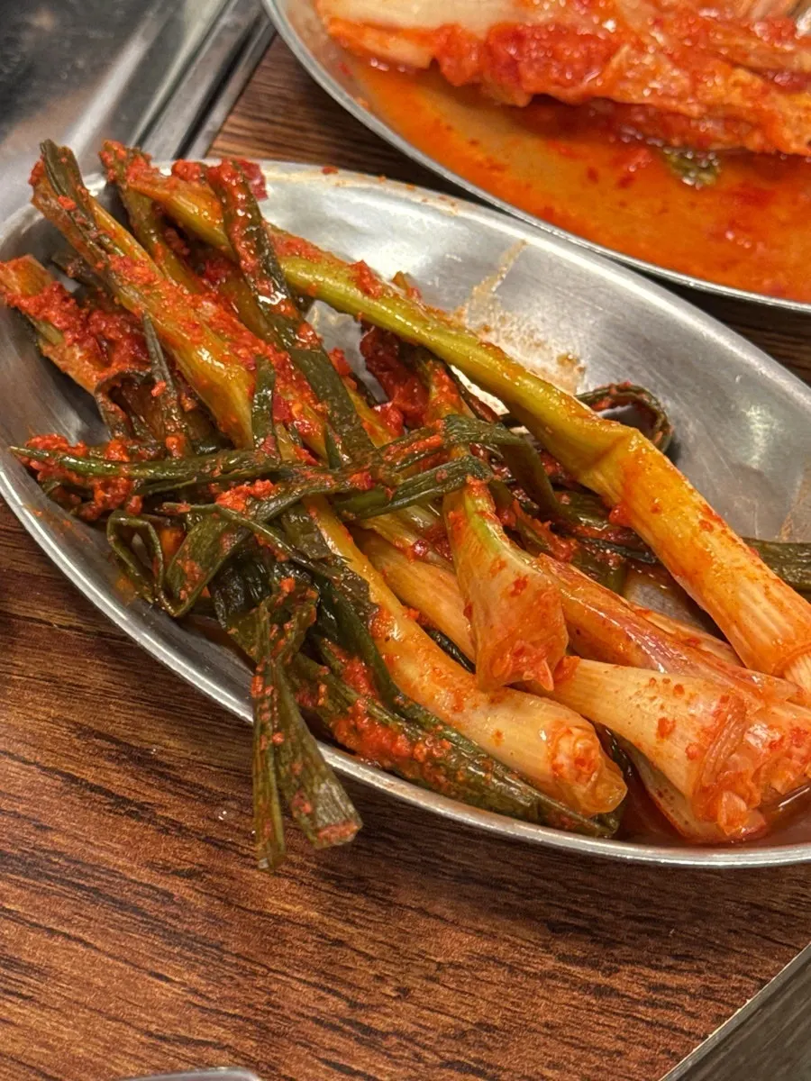 A bite of meat with sharp scallion kimchi