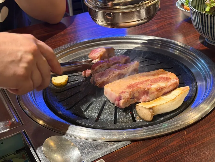 직원이 구워주는 고기살롱 불판 위 고기
